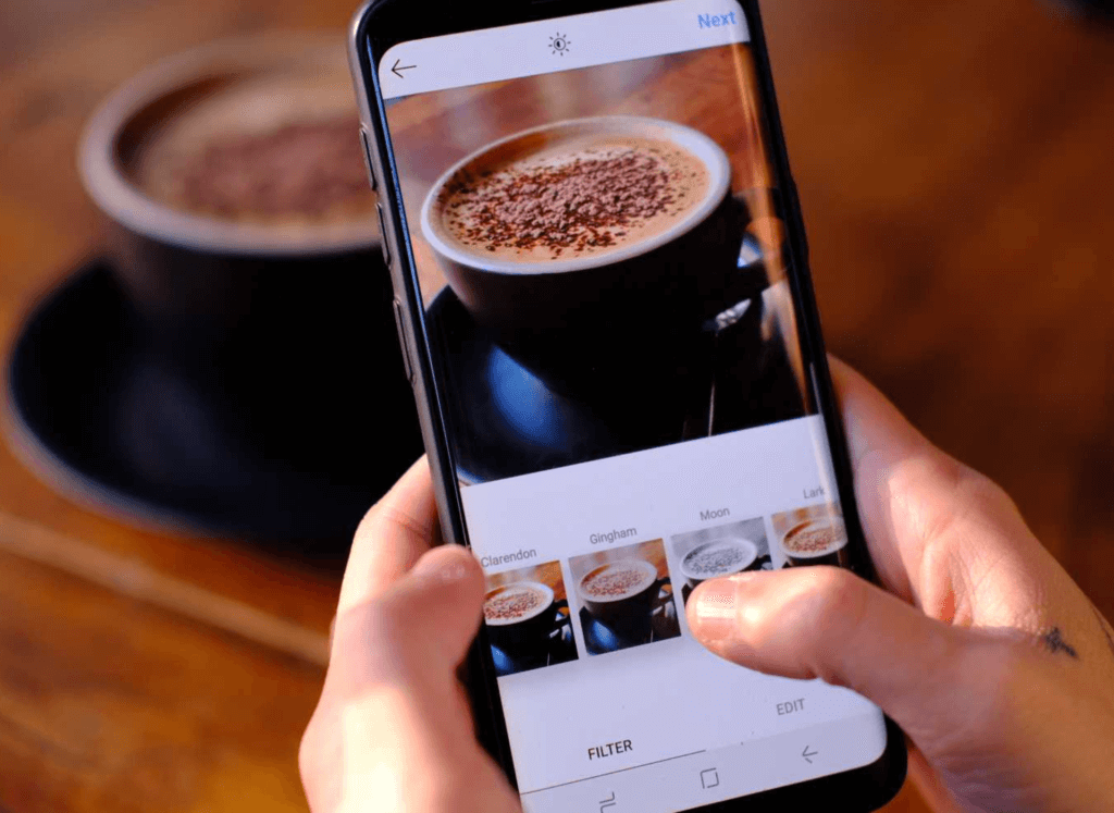 Pessoa fotografando uma xícara de café para o Instagram