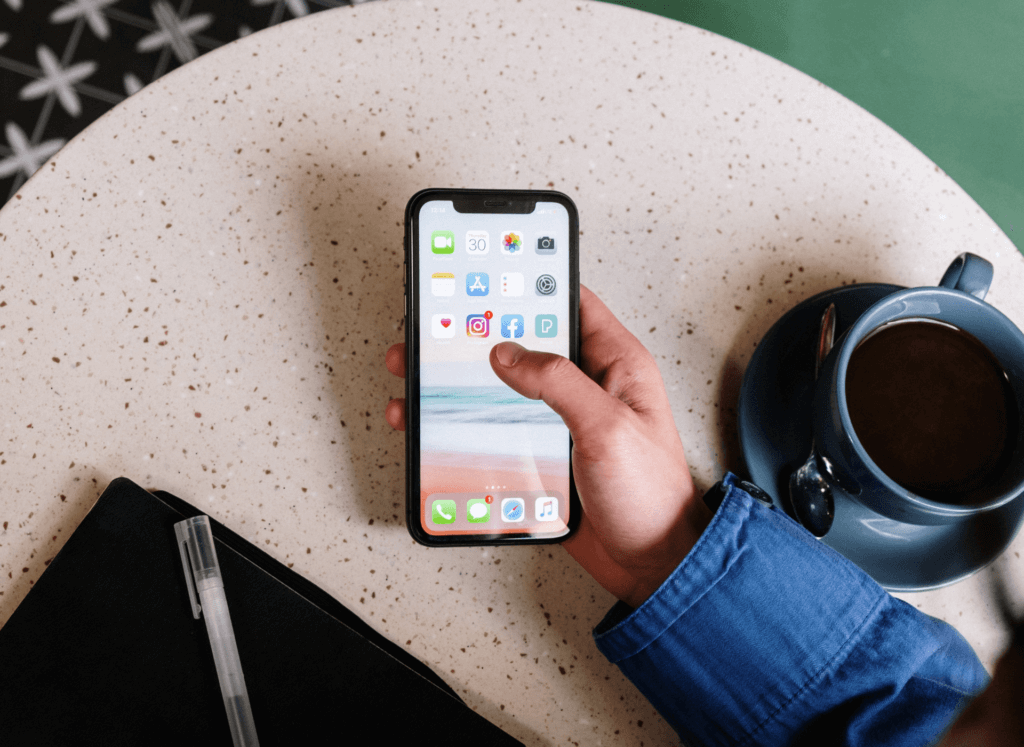 Pessoa usando o smartphone durante uma pausa para o café