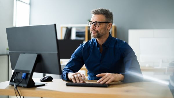 Homem configurando agente de IA de atendimento em seu escritório pelo computador